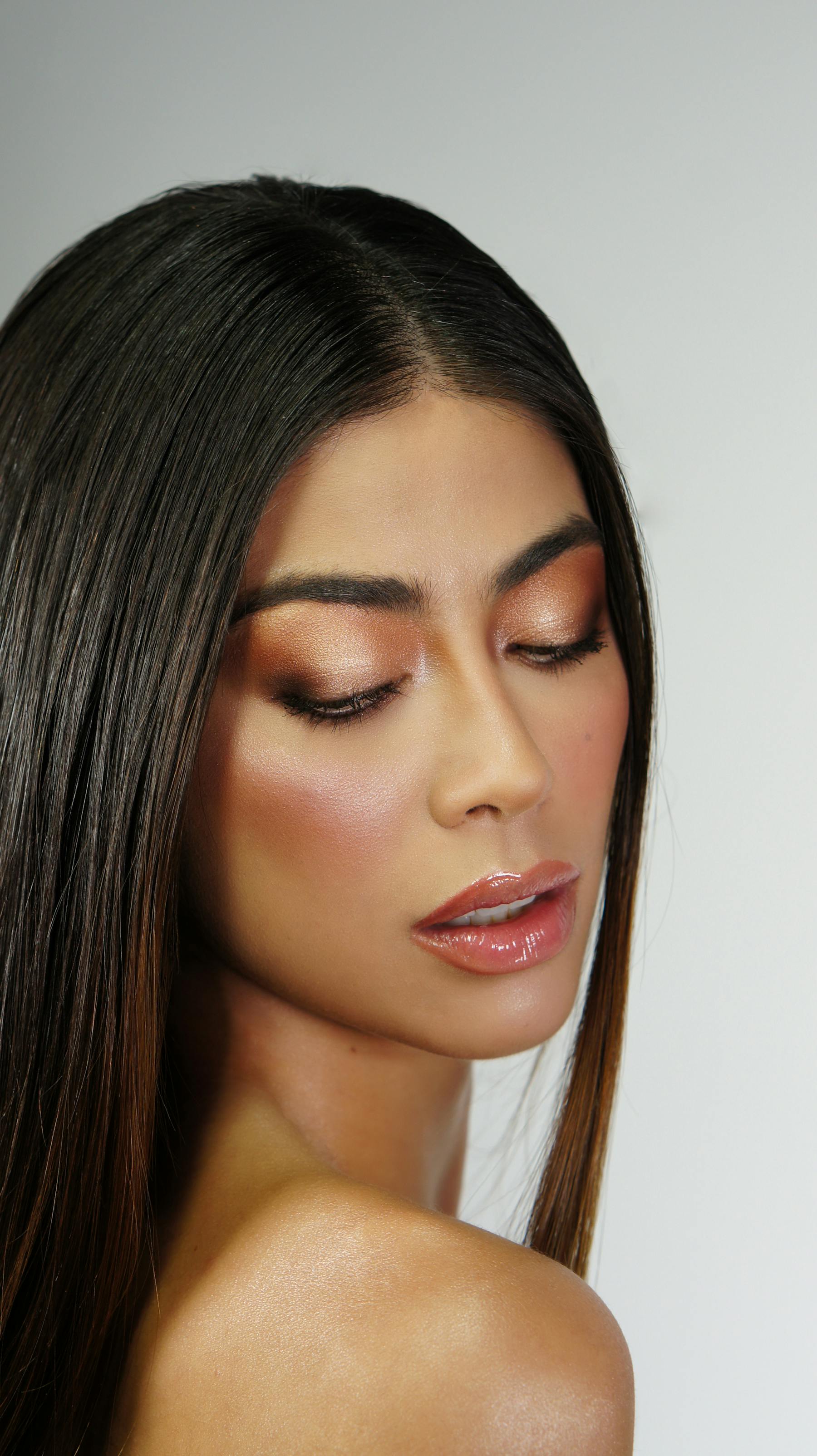 Soft glam makeup being applied, warm berry lip